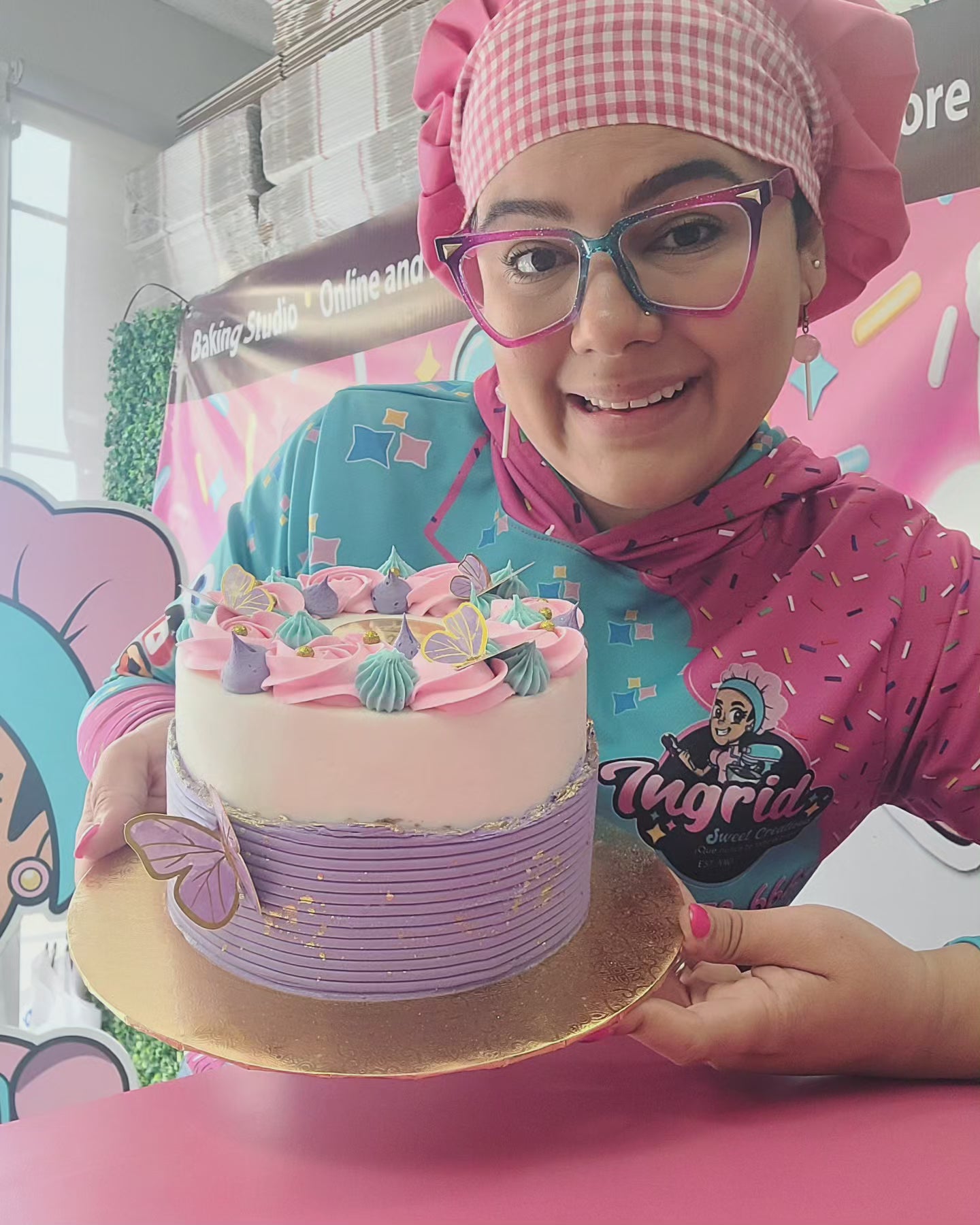 A baker presenting a decorated cake.